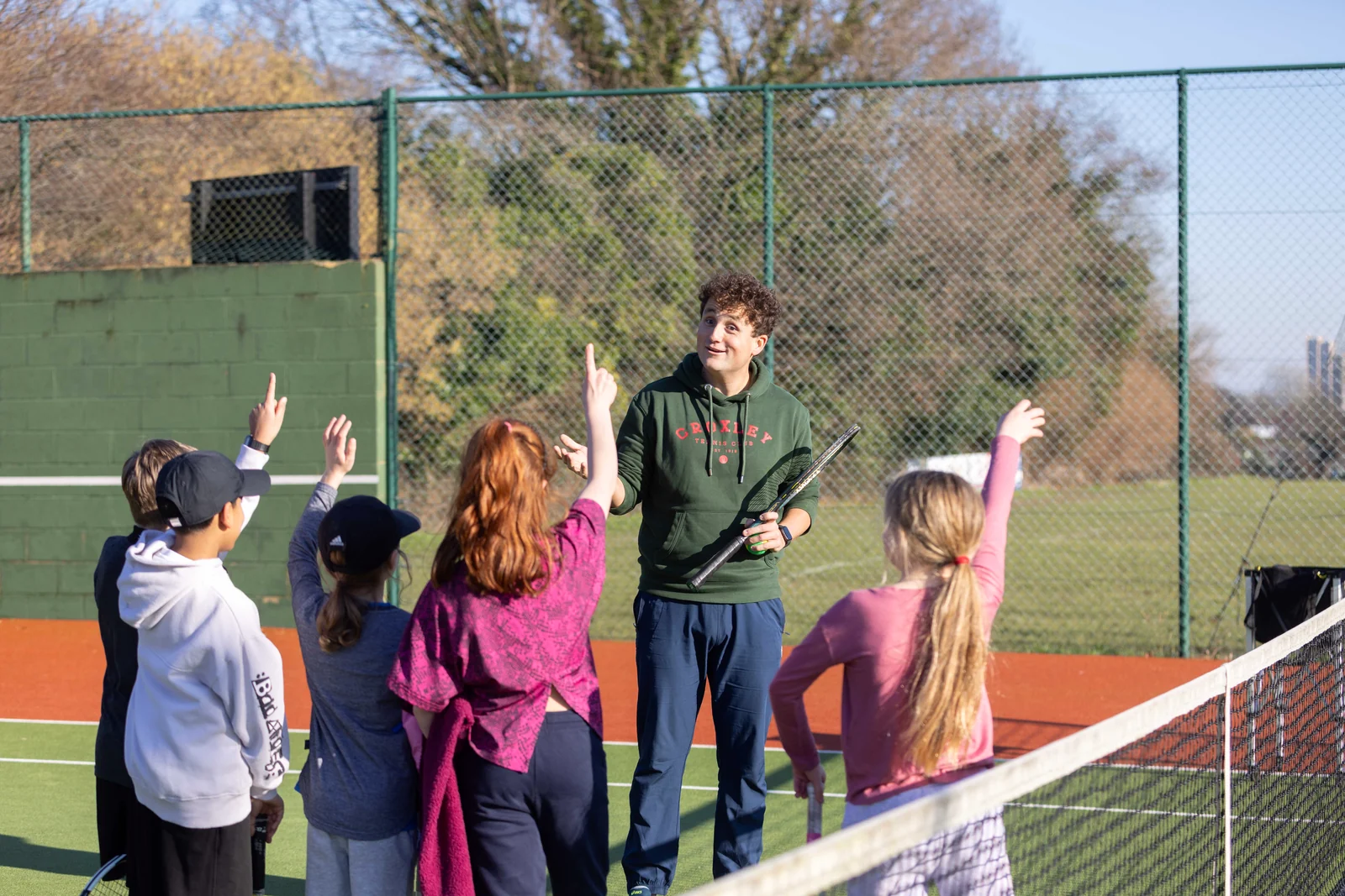 A Tennis by Sam coach leading a group coaching session on court
